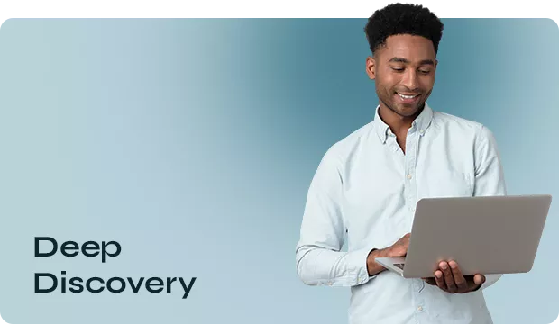 Um homem negro, com uma blusa social de botão branca, segurando um notebook, ao lado dele esta escrito Deep Discovery